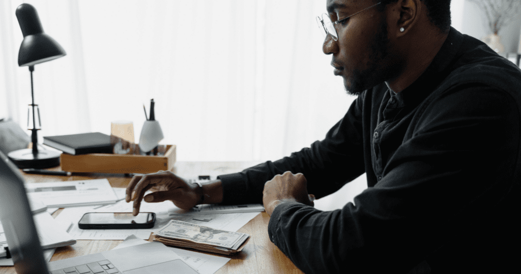 Should landlords hire a collections agency for unpaid rent - mobile image of male landlord reviewing late rent payments.