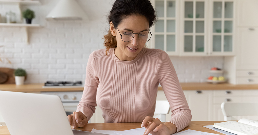 Spanish female landlord using laptop to report tenant rent payments online