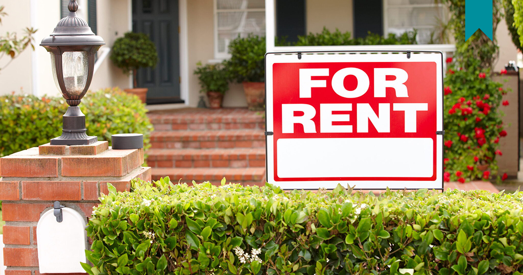 Home with a for rent sign in front.